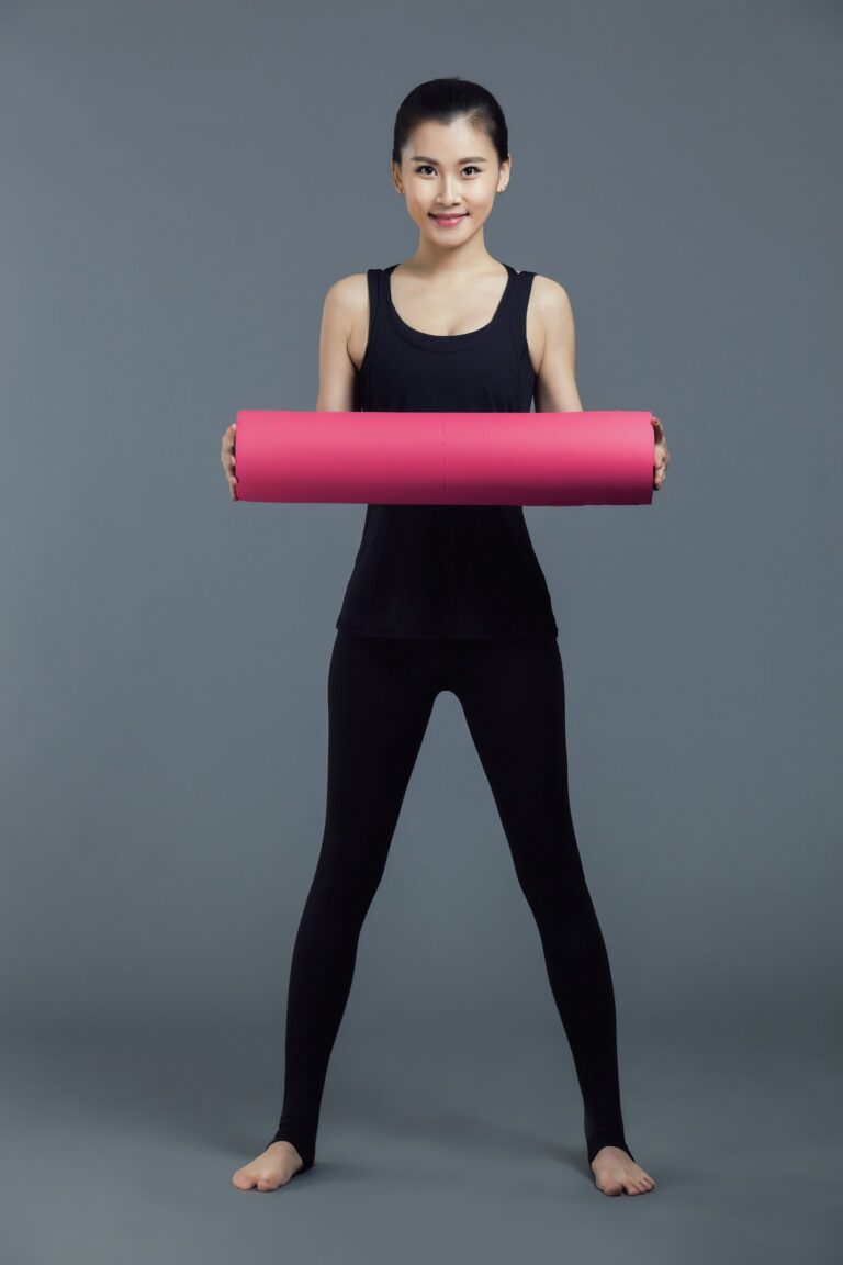 women holding rolled yoga mat