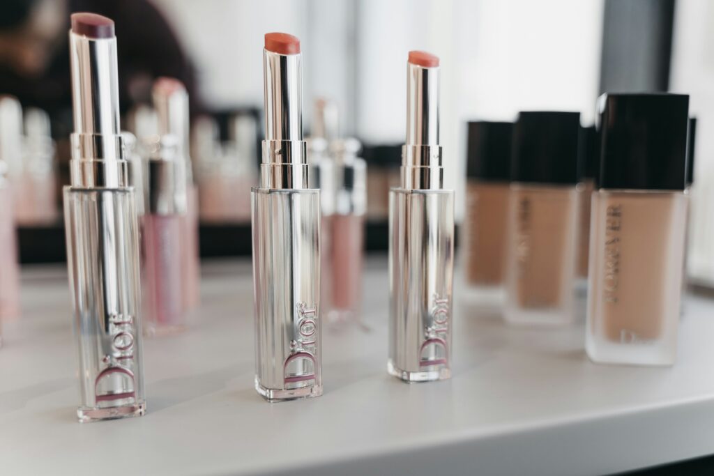 3 lipstick lying on a table along with foundation