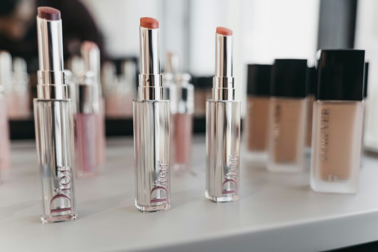 3 lipstick lying on a table along with foundation