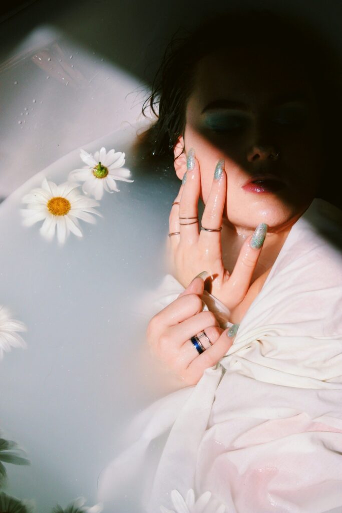 girl with beautiful painted nails having hand on her cheeks
