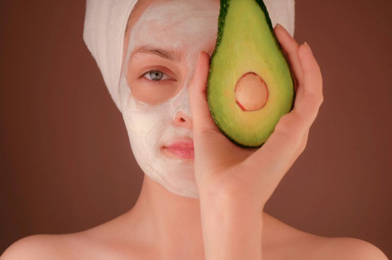 women applied facepack holding avocado in hand