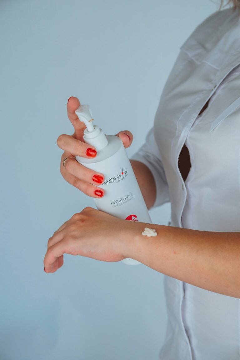 person squeezing skin product on hand