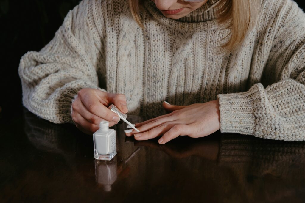 women putting white nail polish