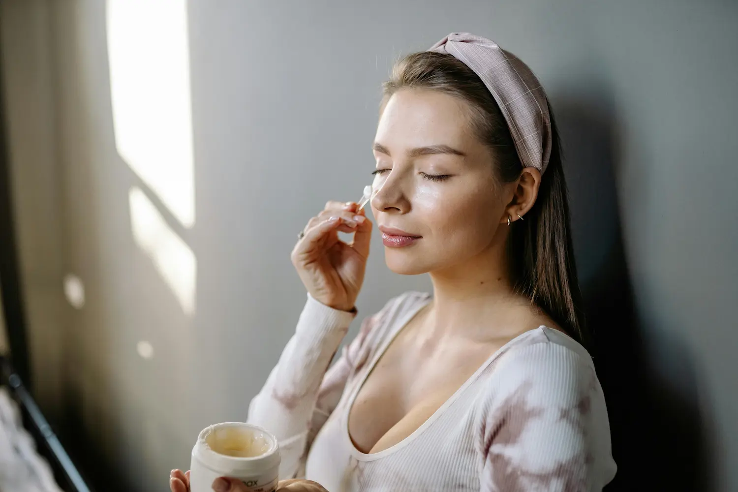 Woman applying night cream for glowing skin during nighttime beauty routine